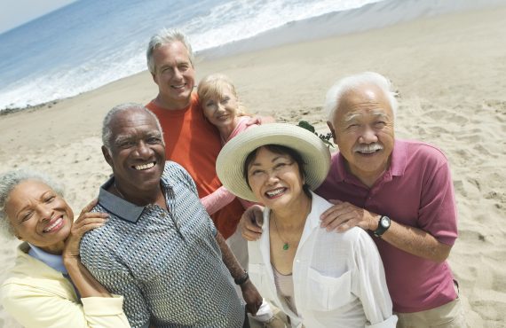 A diverse group of seniors smiling for a beach selfie, representing the joy of Medicare Advantage plans nationwide.