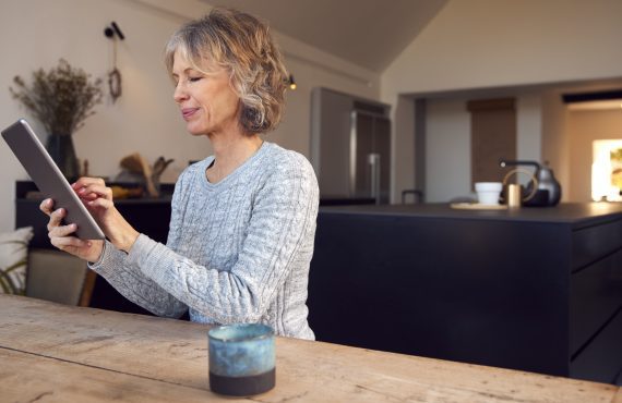 A woman using her iPad to enroll in Medicare Advantage, taking charge of her healthcare.